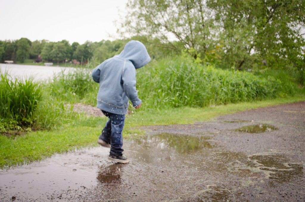 Photo d'un enfant qui saute dans une flaque d'eau